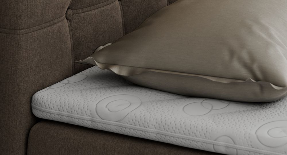 Gestepptes Kopfteil eines braun Bettes. Eine Topper-Matratze liegt auf dem Bett