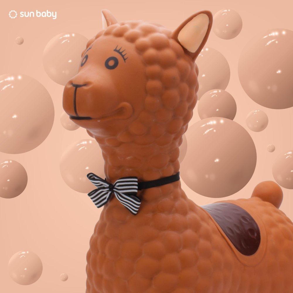 Primer plano de la cabeza de la alpaca con pajarita decorativa.