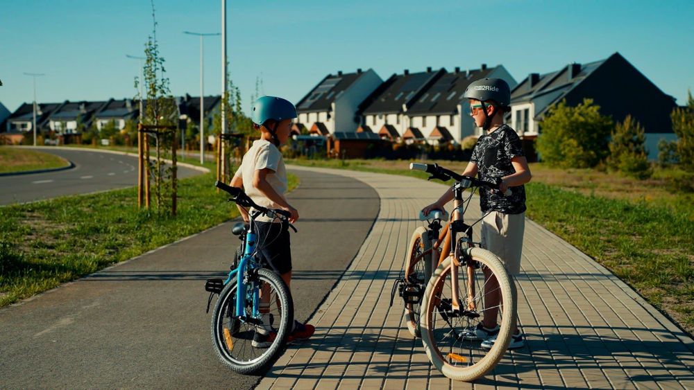 Dos niños con bicicletas SUN BABY en un paseo urbano