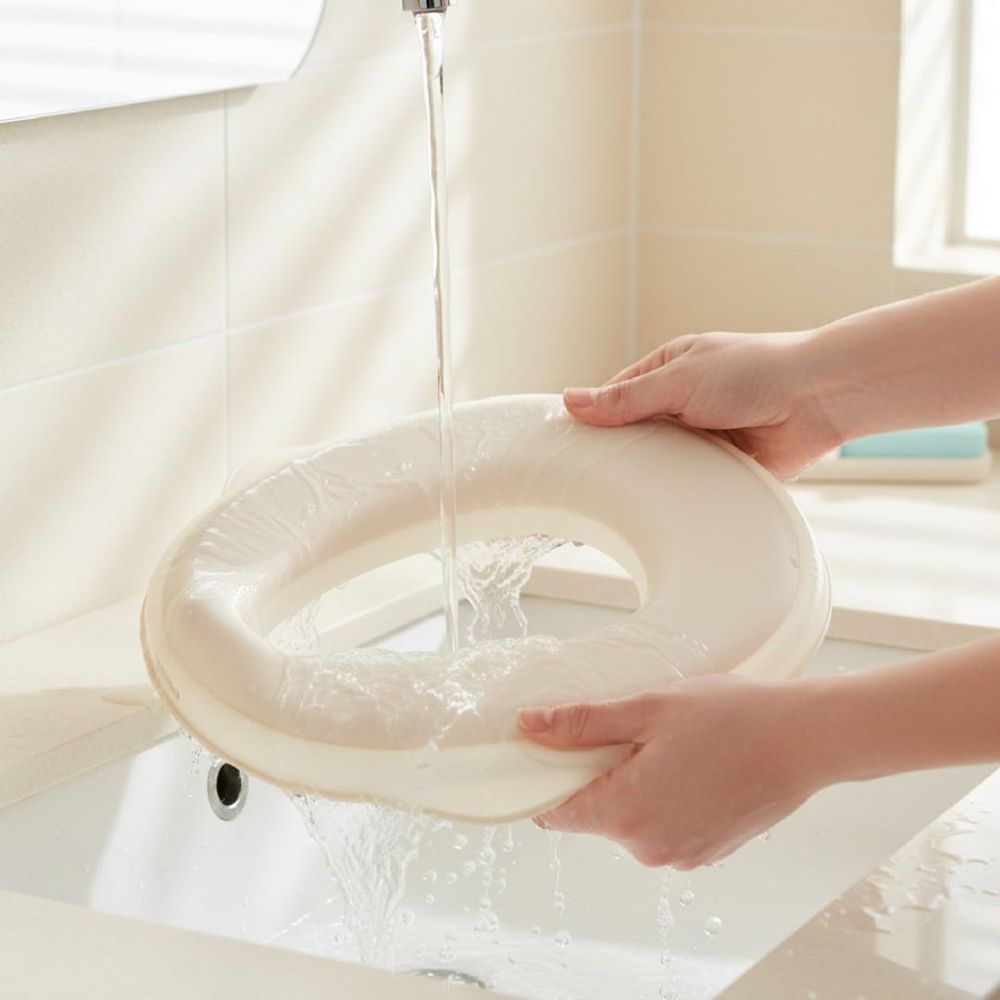 Orinal SUN BABY siendo lavado bajo el grifo en un lavabo.