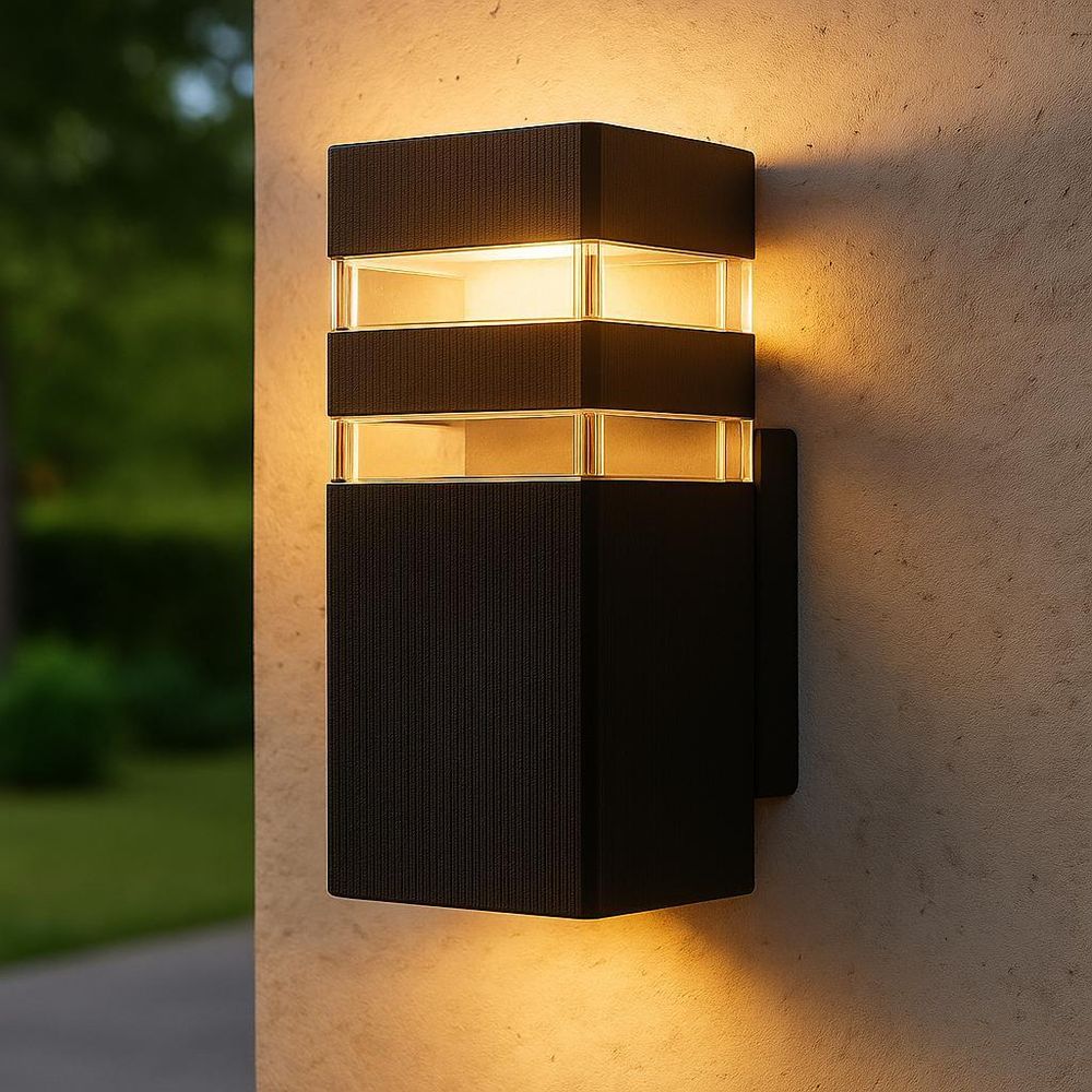 Schwarze LED-Außenwandleuchte mit warmweißem Licht, beleuchtet eine Hauswand bei Abenddämmerung.