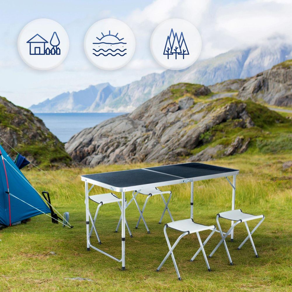Klappbarer Campingtisch mit Stühlen vor malerischer Berg- und Seenlandschaft