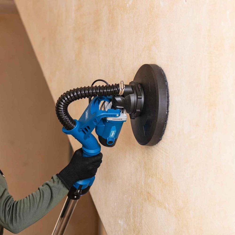 Das Bild zeigt eine Person bei der Arbeit mit dem Wand- und Deckenschleifer.