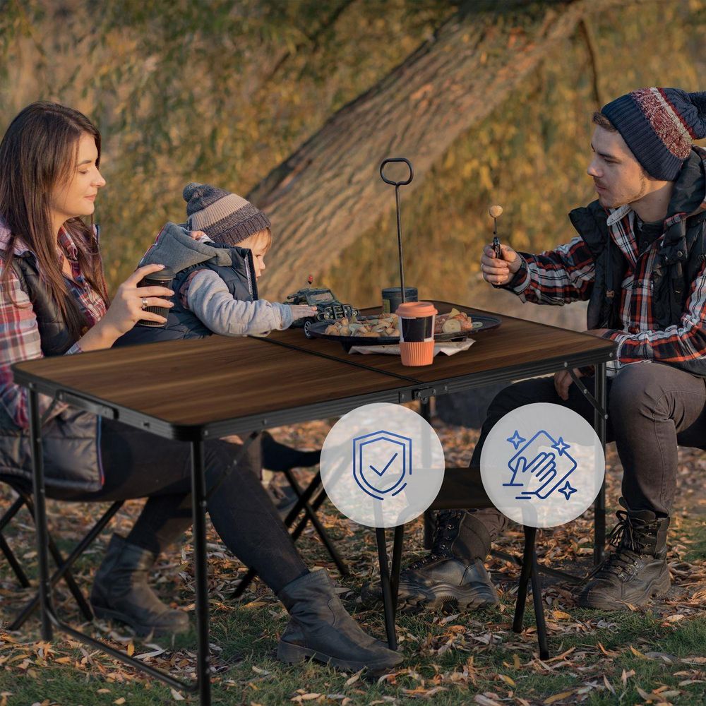 Familie beim Picknick am Camping-Tisch