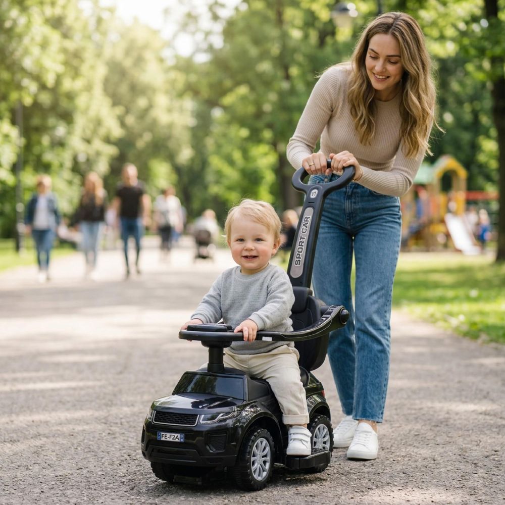 Ouder duwt kind op de loopauto in het park