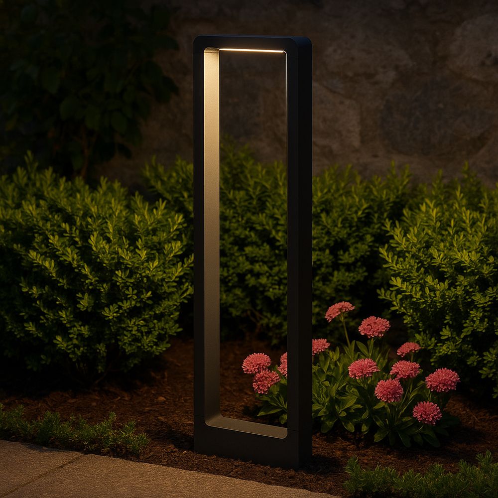 Schwarze LED Gartenleuchte beleuchtet Blumenbeet bei Nacht.