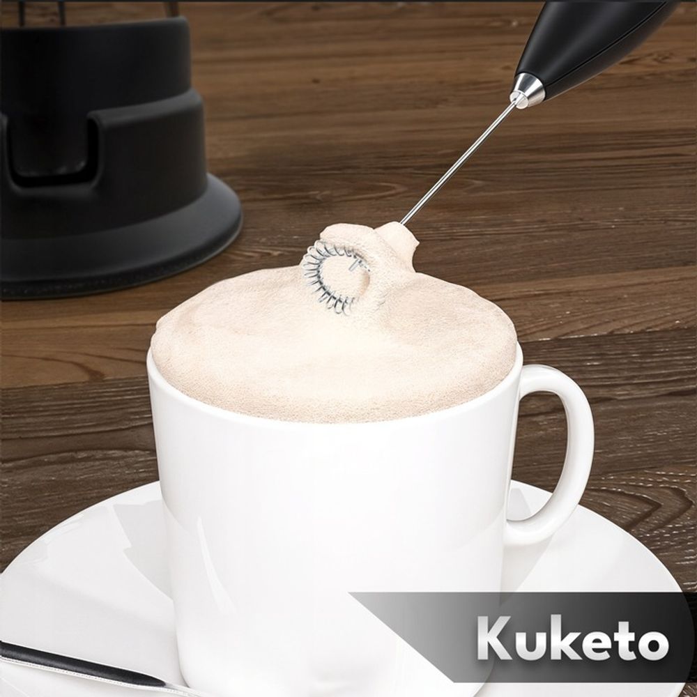 Weiße Tasse mit cremigem Milchschaum – Kuketo Milchaufschäumer in Aktion, inkl. Ständer.