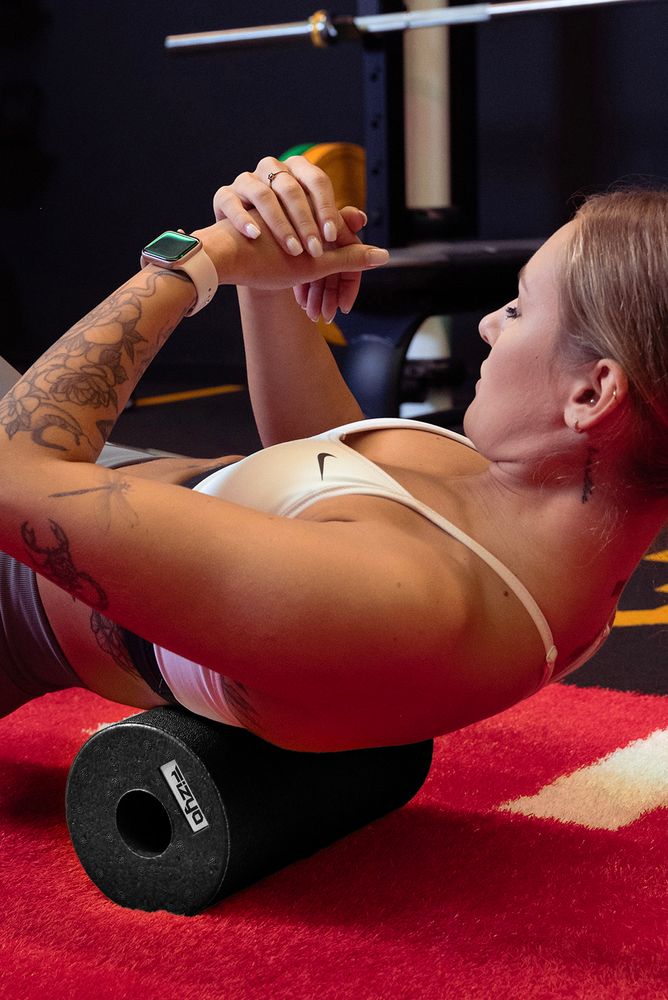 Training mit der FIZYO Massagerolle – Person führt Entspannungs- und Kräftigungsübungen durch.