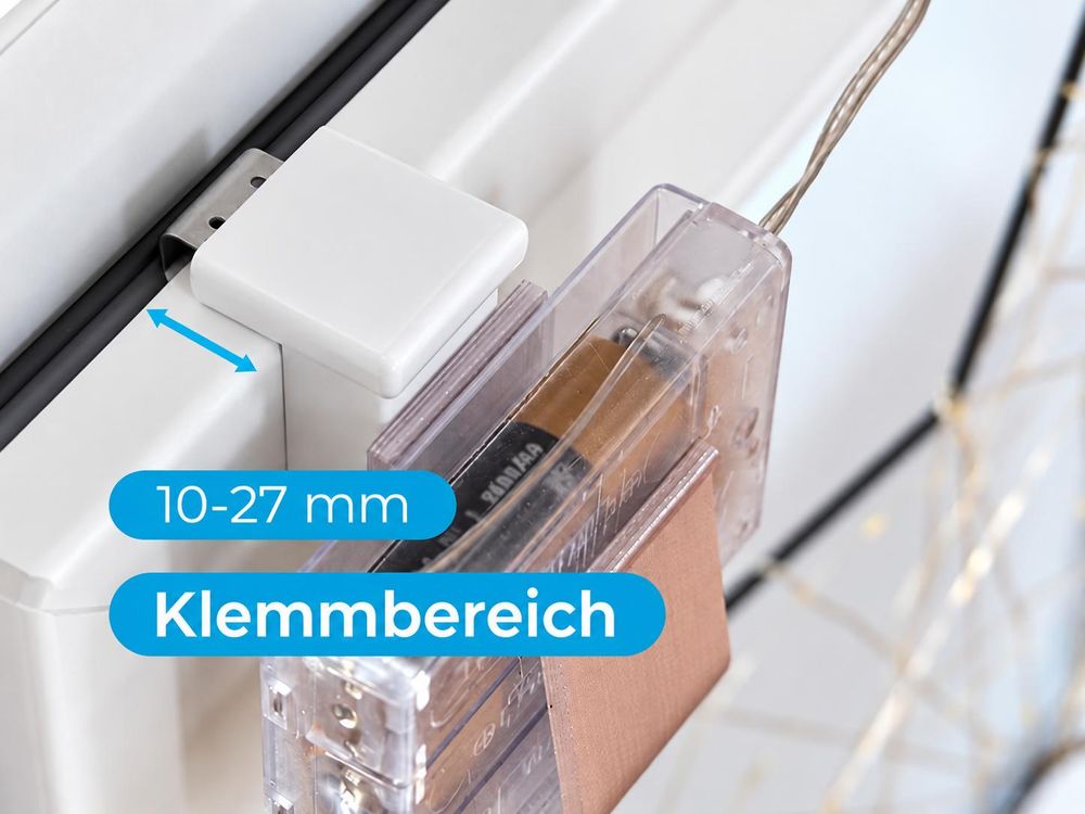 Das Bild zeigt, wie der Fensterhaken mit Batteriehalter an das Fenster geklemmt wird