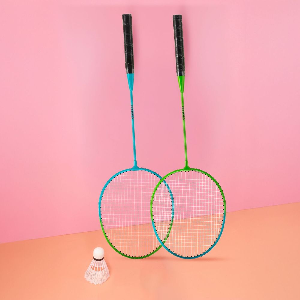 Zwei Badmintonschläger und ein Federball vor pinkfarbenem Hintergrund.