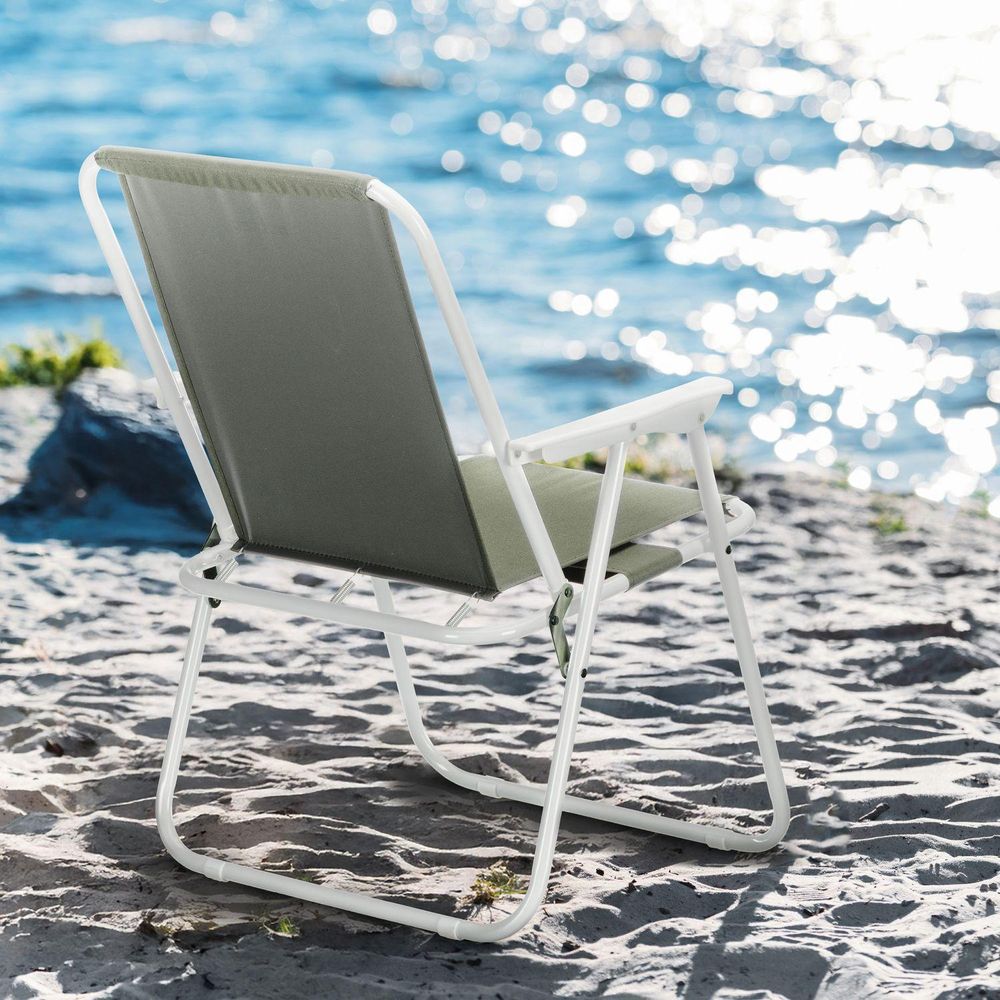 Leerer Klappstuhl auf sandigem Strand mit Blick aufs Meer, bereit zum Entspannen