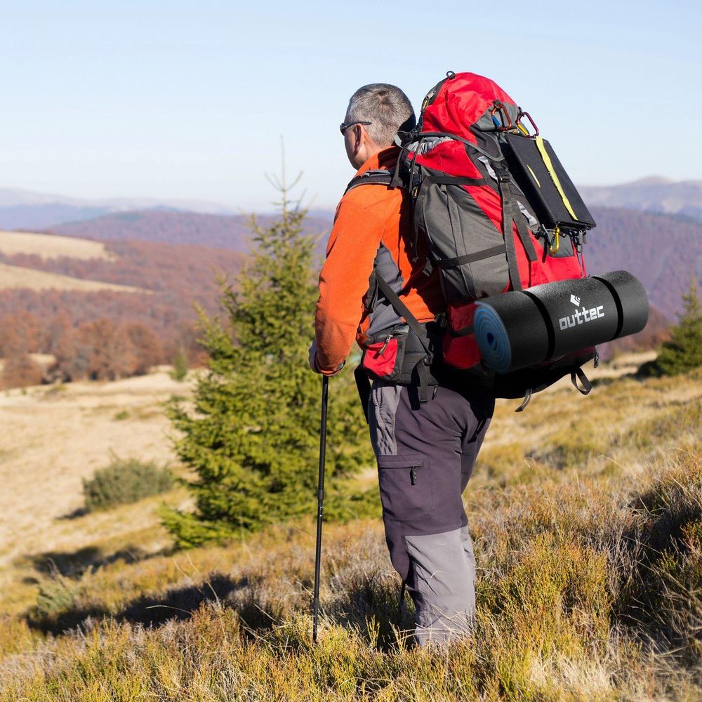 Wanderer mit Rucksack und Outtec Isomatte auf Bergtour, Blick auf die Landschaft