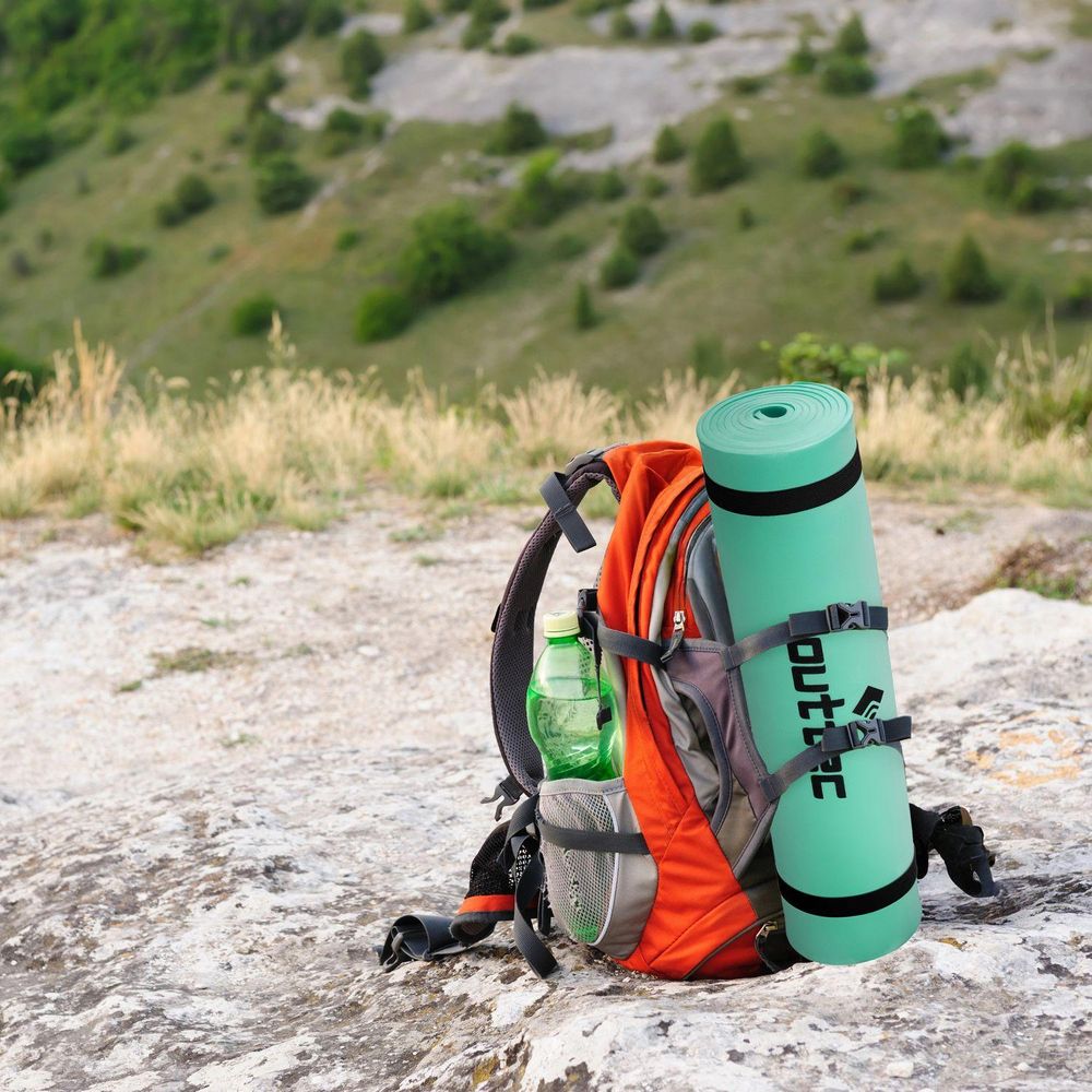 Gerollte Outtec Isomatte am orangefarbenen Rucksack befestigt. Bereit für Wanderungen