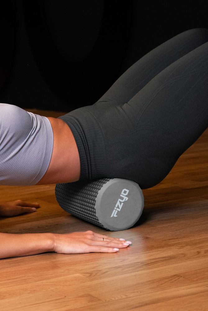 Trening Fitness z wałkiem do masażu z wypustkami 30x15 cm FIZYO — osoba wykonuje ćwiczenia