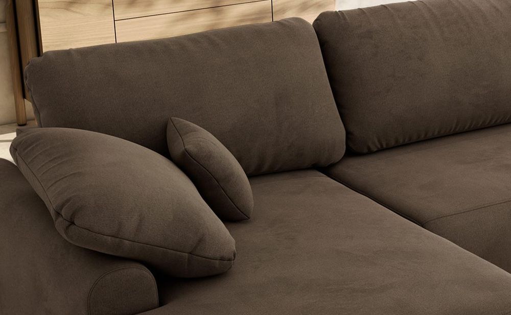Detailansicht eines grauen Sofas mit breiten Sitzpolstern und weichen Rückenkissen.