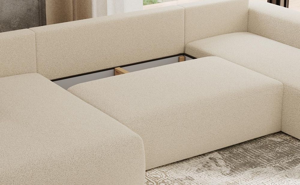 Detailansicht eines grauen Sofas mit Bettkasten und gepolsterter Sitzfläche.