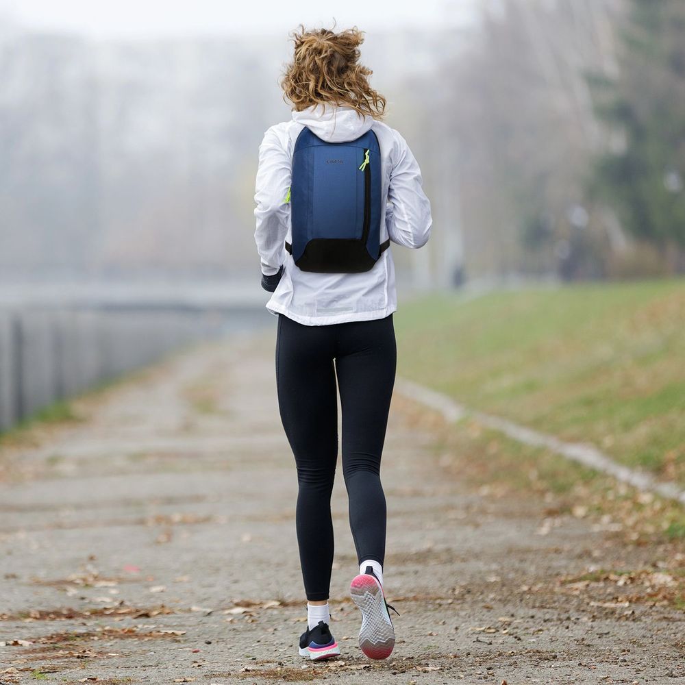 Frau mit blauem Outtec Rucksack beim Joggen im Park.