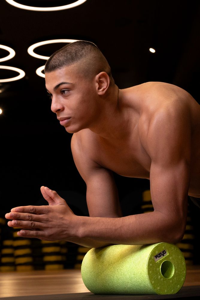 Training mit der FIZYO Massagerolle – Person führt Entspannungs- und Kräftigungsübungen durch.
