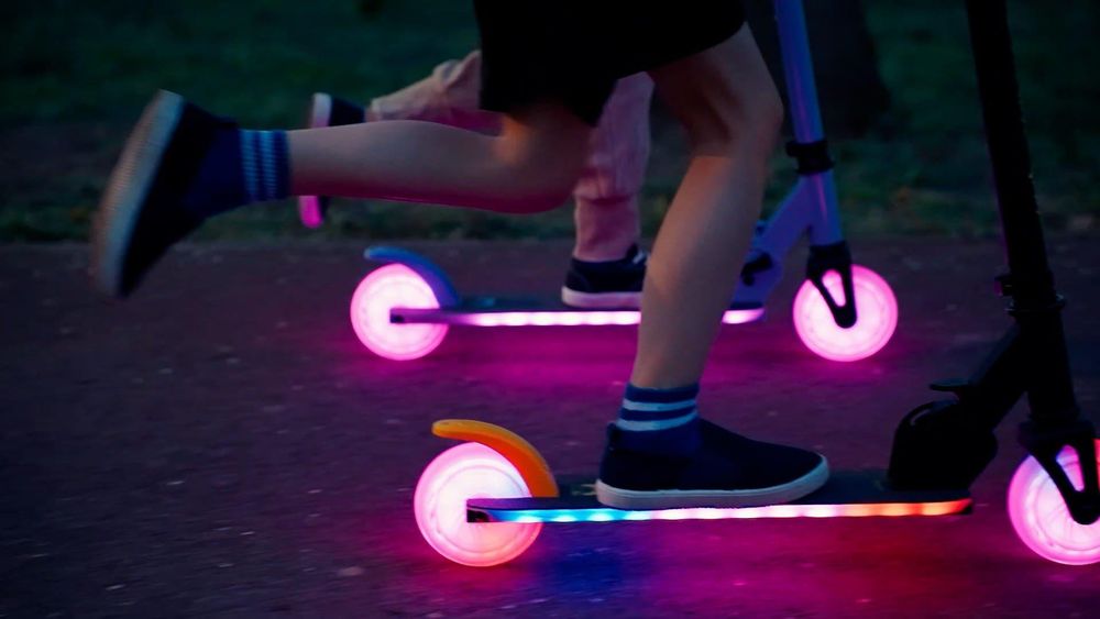 Close-up van kinderen die rijden op steps met verlichte wielen en dek.