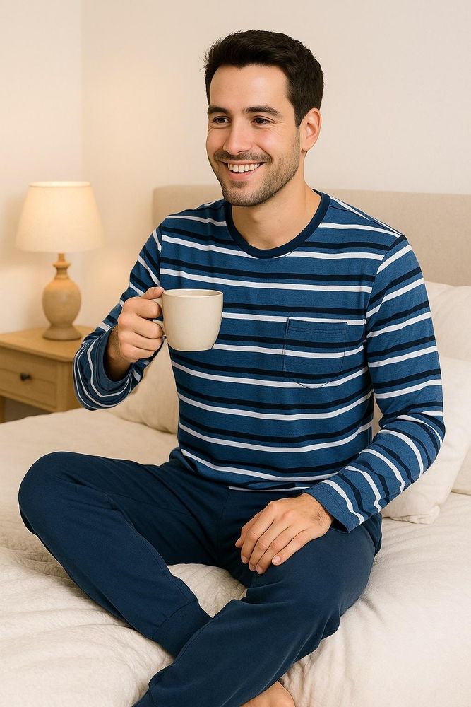 Mann trägt gestreiften langen Herrenschlafanzug mit dunkelblauer Hose im Schlafzimmer.
