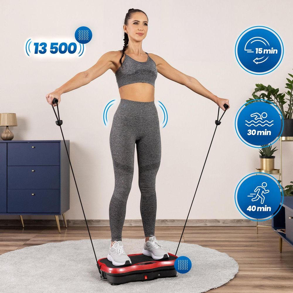 Eine Frau in Sportkleidung trainiert mit Expandern auf einer roten Vibrationsplatte