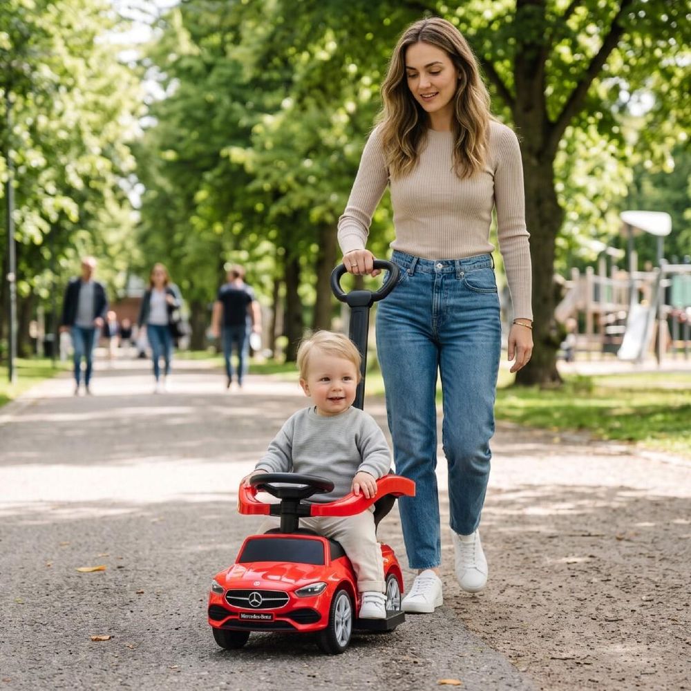 Maman poussant son enfant sur le porteur Mercedes-Benz dans un parc