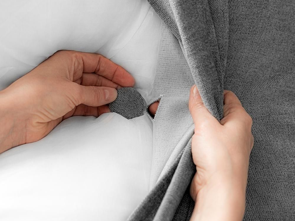 Detailansicht der Knopfheftung und der weißen Kissenfüllung.
