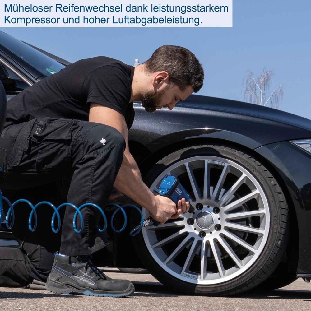 Das Bild zeigt eine Person beim Reifen wechseln mit Hilfe des Kompressors.