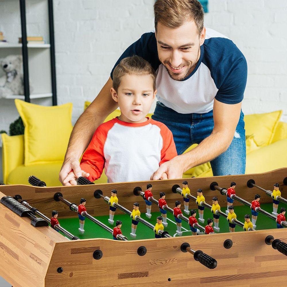 Vater und Sohn spielen begeistert Tischfußball zu Hause.