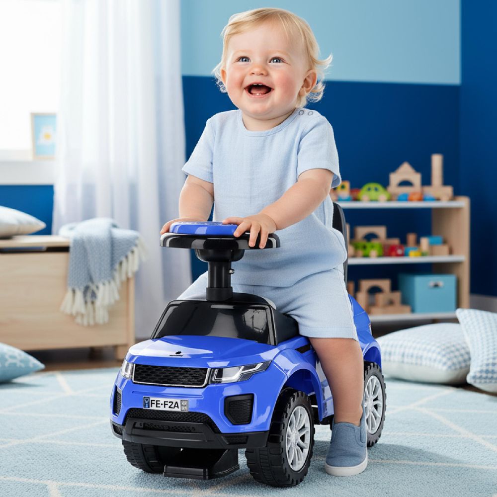 Niño jugando felizmente con el correpasillos azul en una habitación infantil.