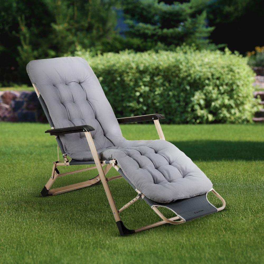 Komfortable graue Gartenliege mit weichen Kissen im Garten