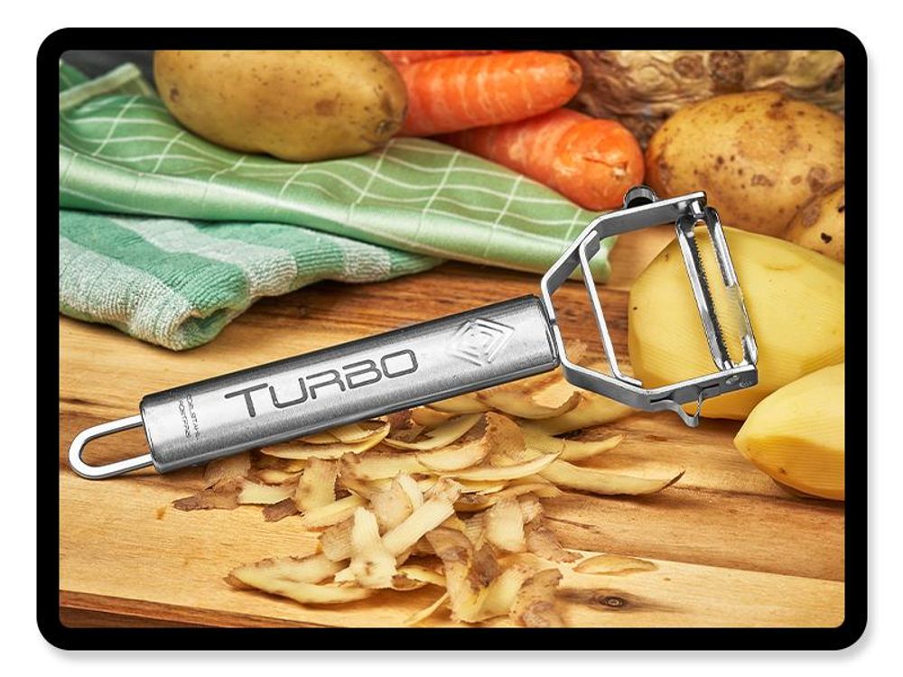 TURBO Schäler mit geschälten Kartoffeln und Schalen auf einem Holzbrett