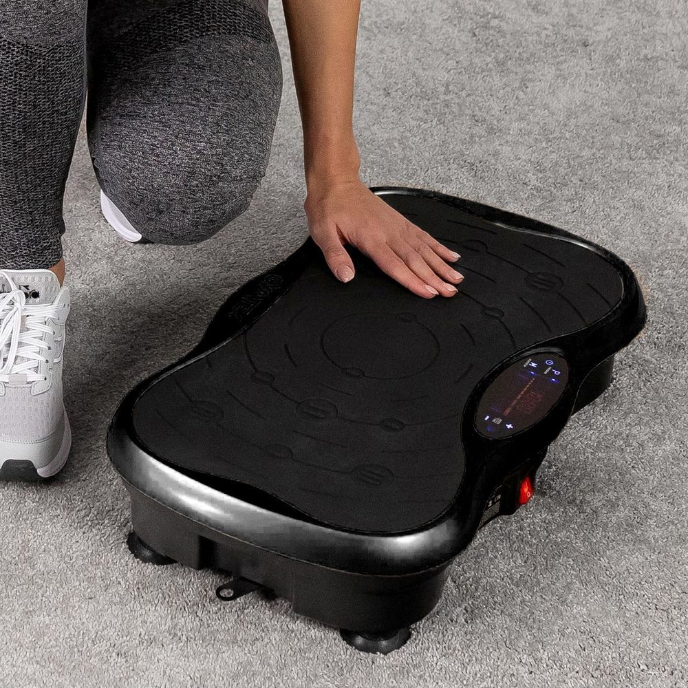Frau testet die Oberfläche der Vibrationsplatte.