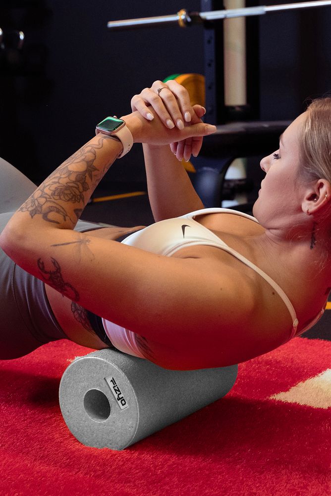 Training mit der FIZYO Massagerolle – Person führt Entspannungs- und Kräftigungsübungen durch.