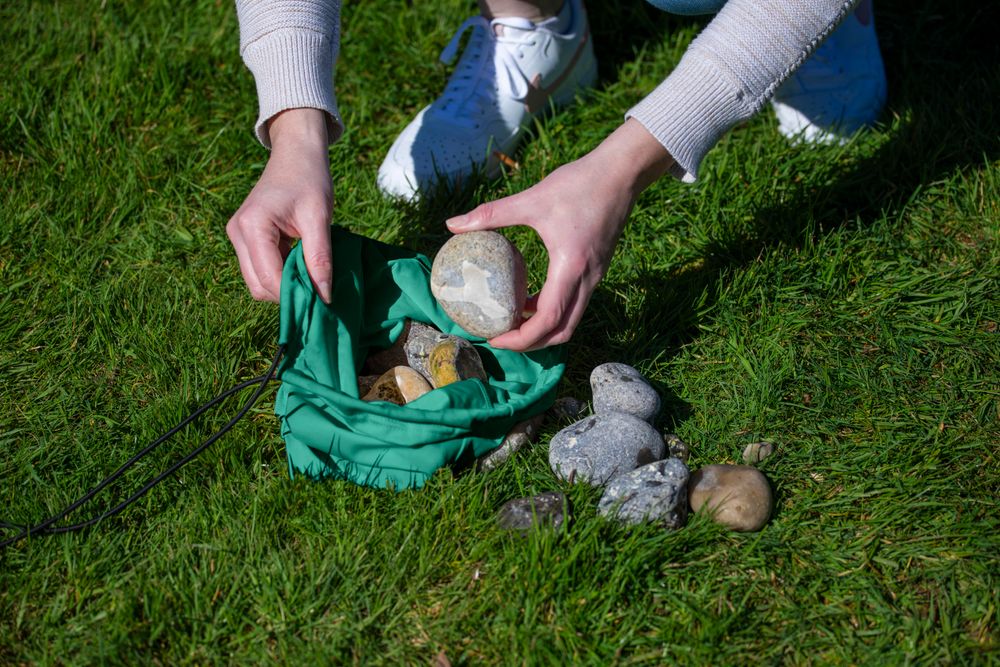 Das Bild zeigt, wie die Sandsäcke mit Steinen befüllt werden