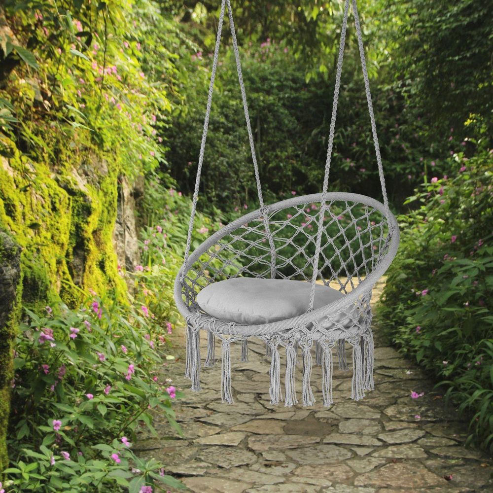 Hängesessel im Garten, umgeben von Pflanzen und Bäumen