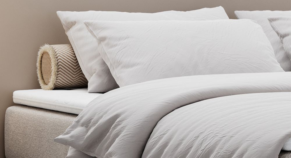 Beige Bett mit Kunstlederbezug. Obere Matratze liegt auf dem Bett