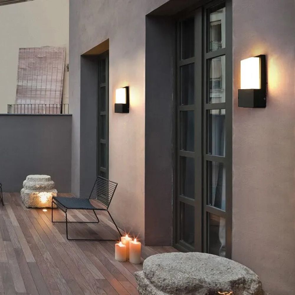 Schwarze Wandlampen, schlichte Eleganz, beleuchten Terrasse mit Holzboden.