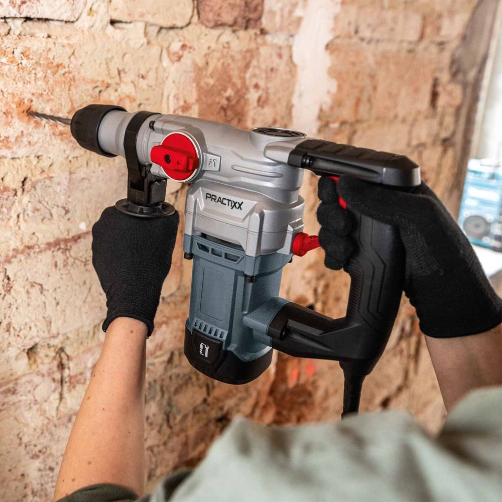 Das Bild zeigt eine Person, die mit dem Elektro-Bohrhammer PX-BH-5 ein Loch in eine Wand.