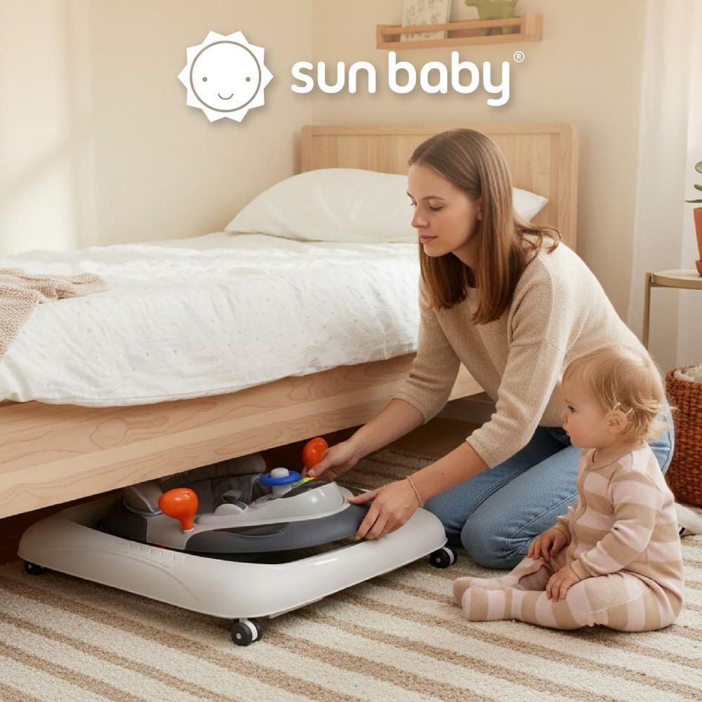 Moeder bergt de opgevouwen loopstoel op onder het bed met haar baby erbij.