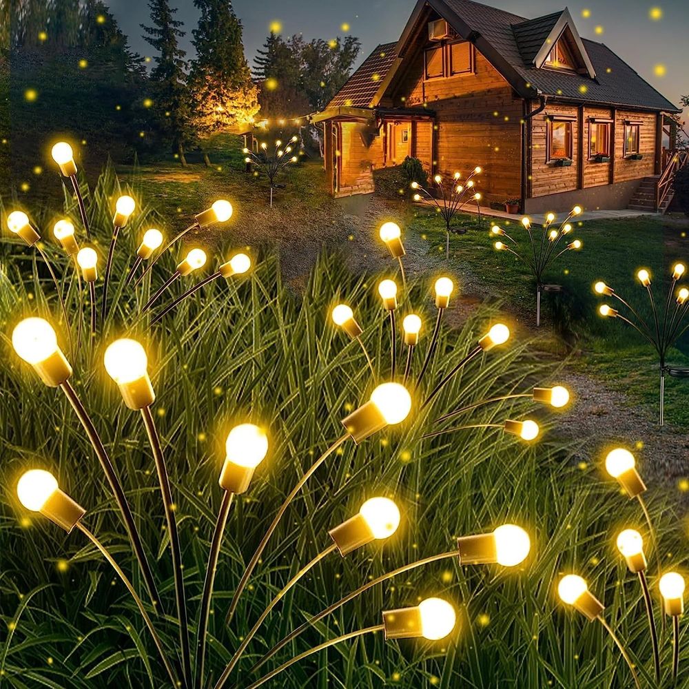 Dekorative Lampen mit Erdspieß sehen aus wie Glühwürmchen im Gras.