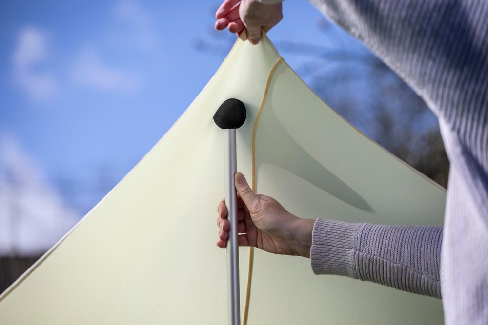Das Bild zeigt eine Aluminiumstange und wie der Stoff über die Stange gespannt wird