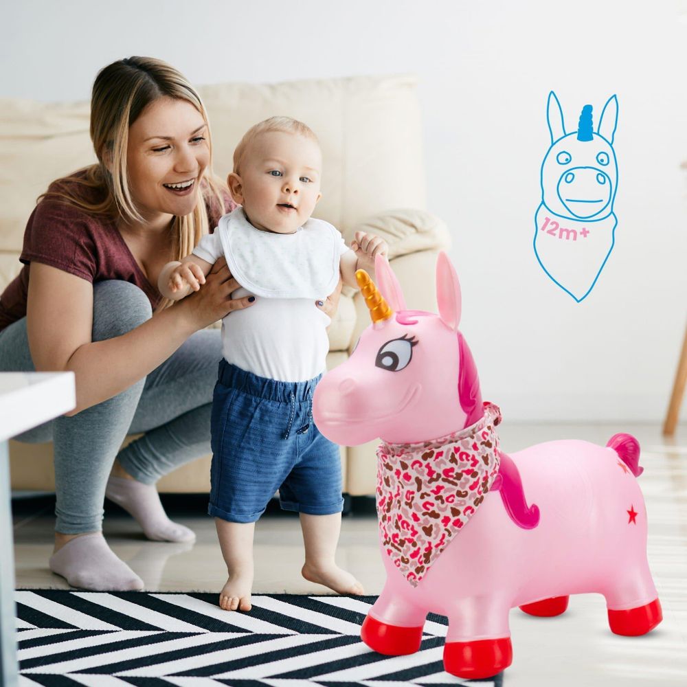Mutter unterstützt ihr Kind beim Spielen mit dem Einhorn-Hüpftier im Wohnzimmer.