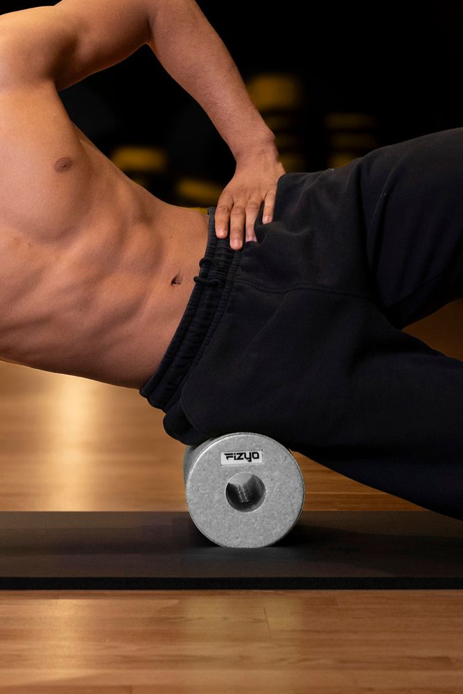 Training mit der FIZYO Massagerolle – Person führt Entspannungs- und Kräftigungsübungen durch.