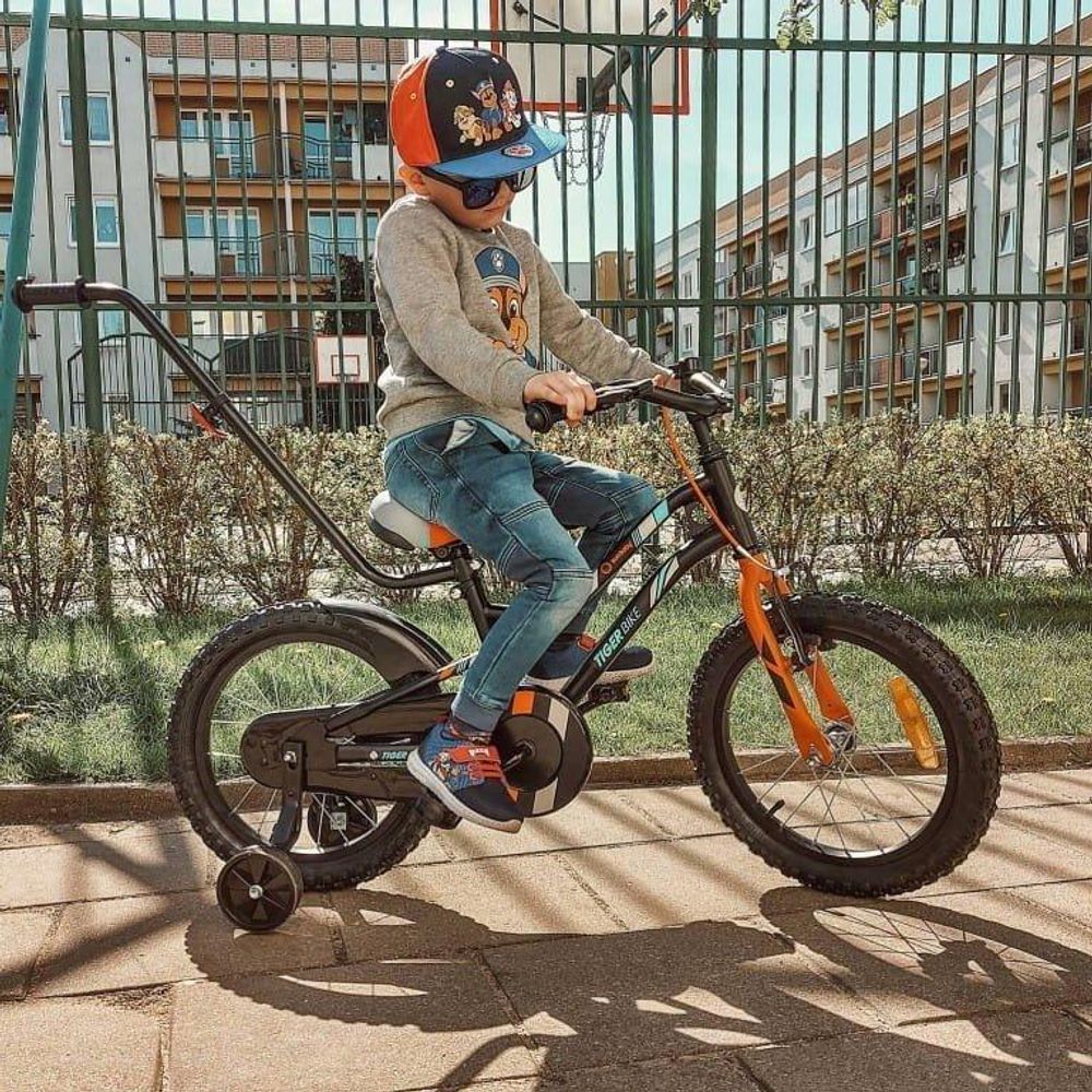 Niño montando la bicicleta Tiger Bike en un parque.