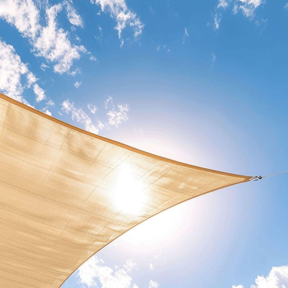 Rechteckiges Sonnensegel vor blauem Himmel schützt vor der Sonne