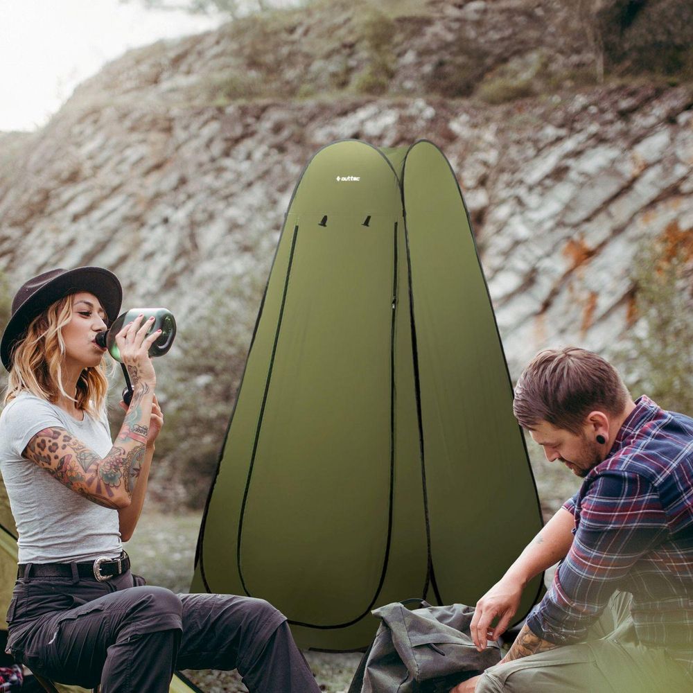 Paar beim Camping. Grünes Pop-up Duschzelt/Toilettenzelt als tragbares Umkleidezelt