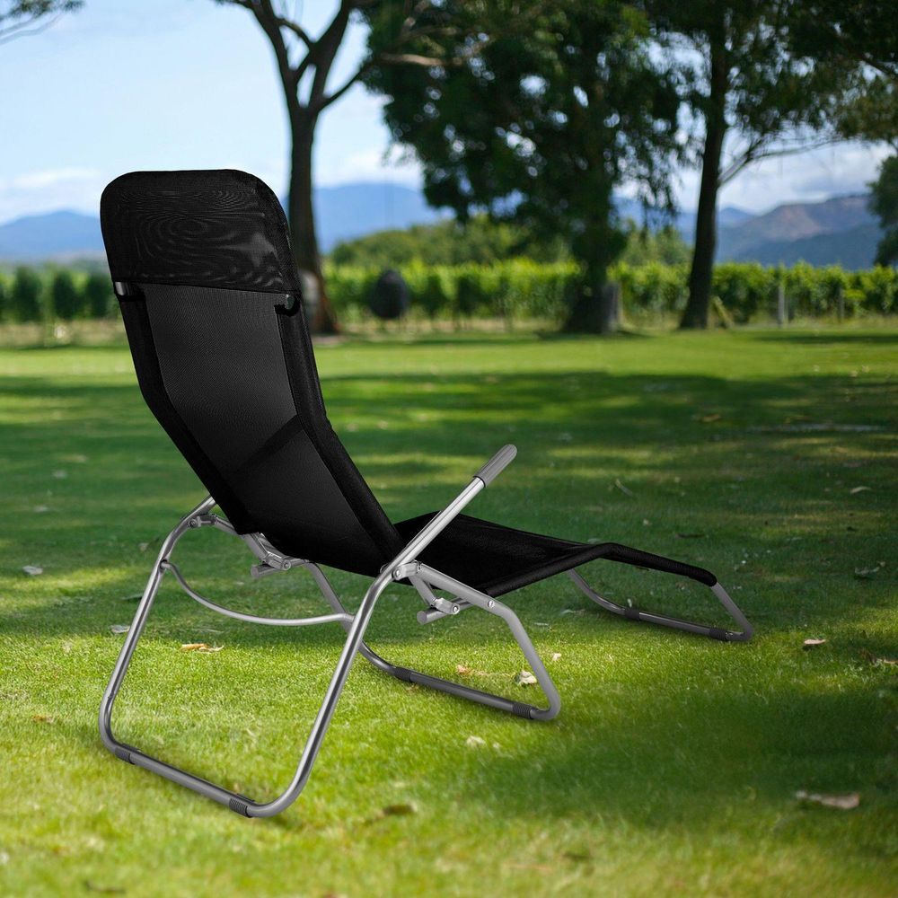 Schwarze Liege im Garten mit Blick auf Bäume und Berge. Entspannungsbereich