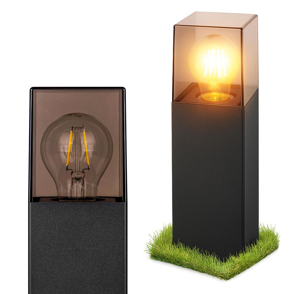 Schwarze Außenleuchte mit Filament-LED in getöntem Glasgehäuse, stehend auf Rasenstück.