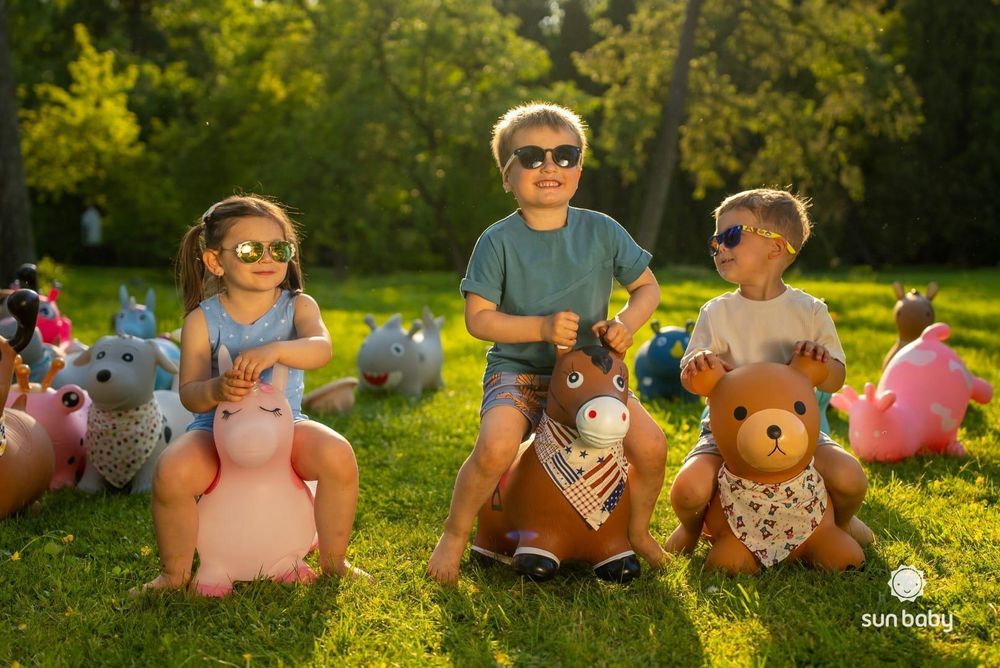 Niños jugando con animales saltarines SUN BABY en el parque